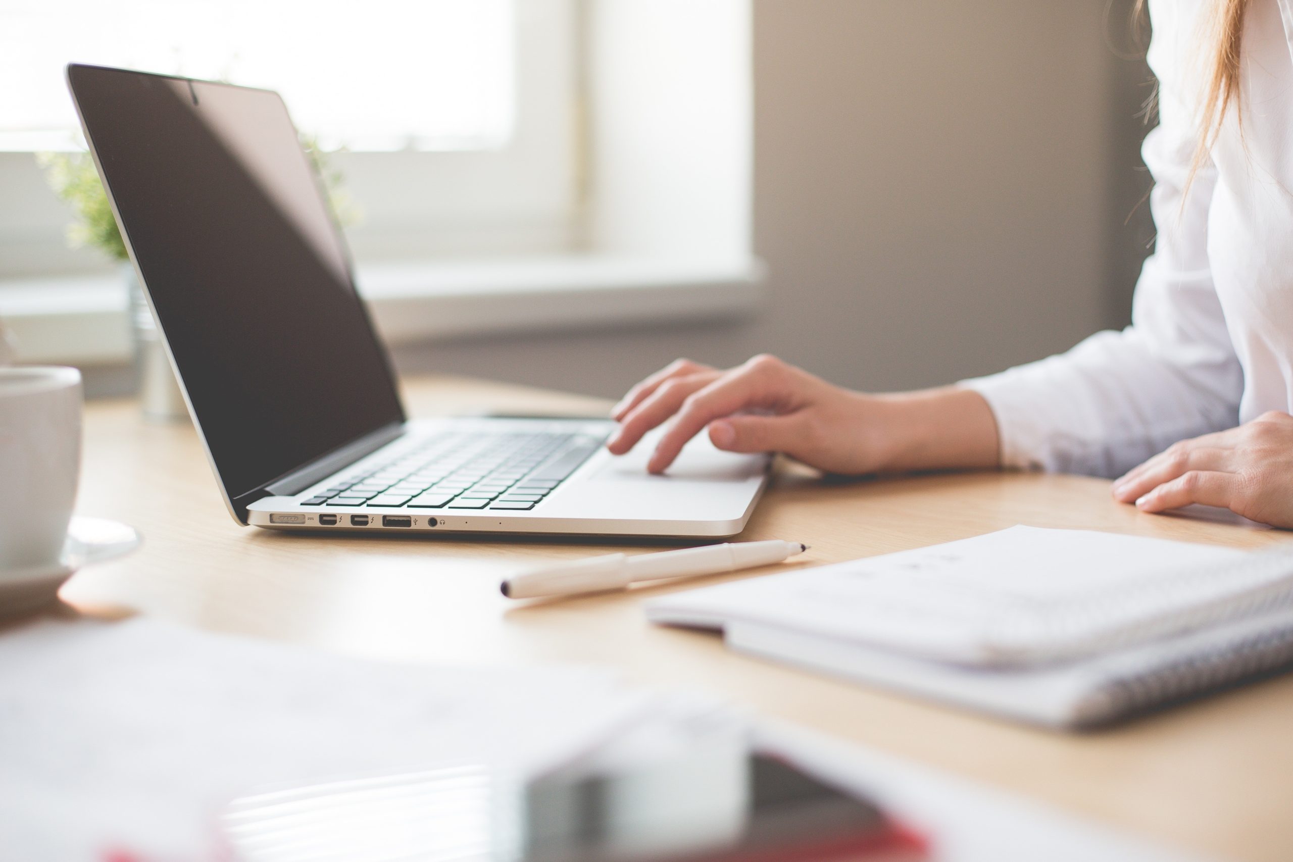 laptop on desk with lady working